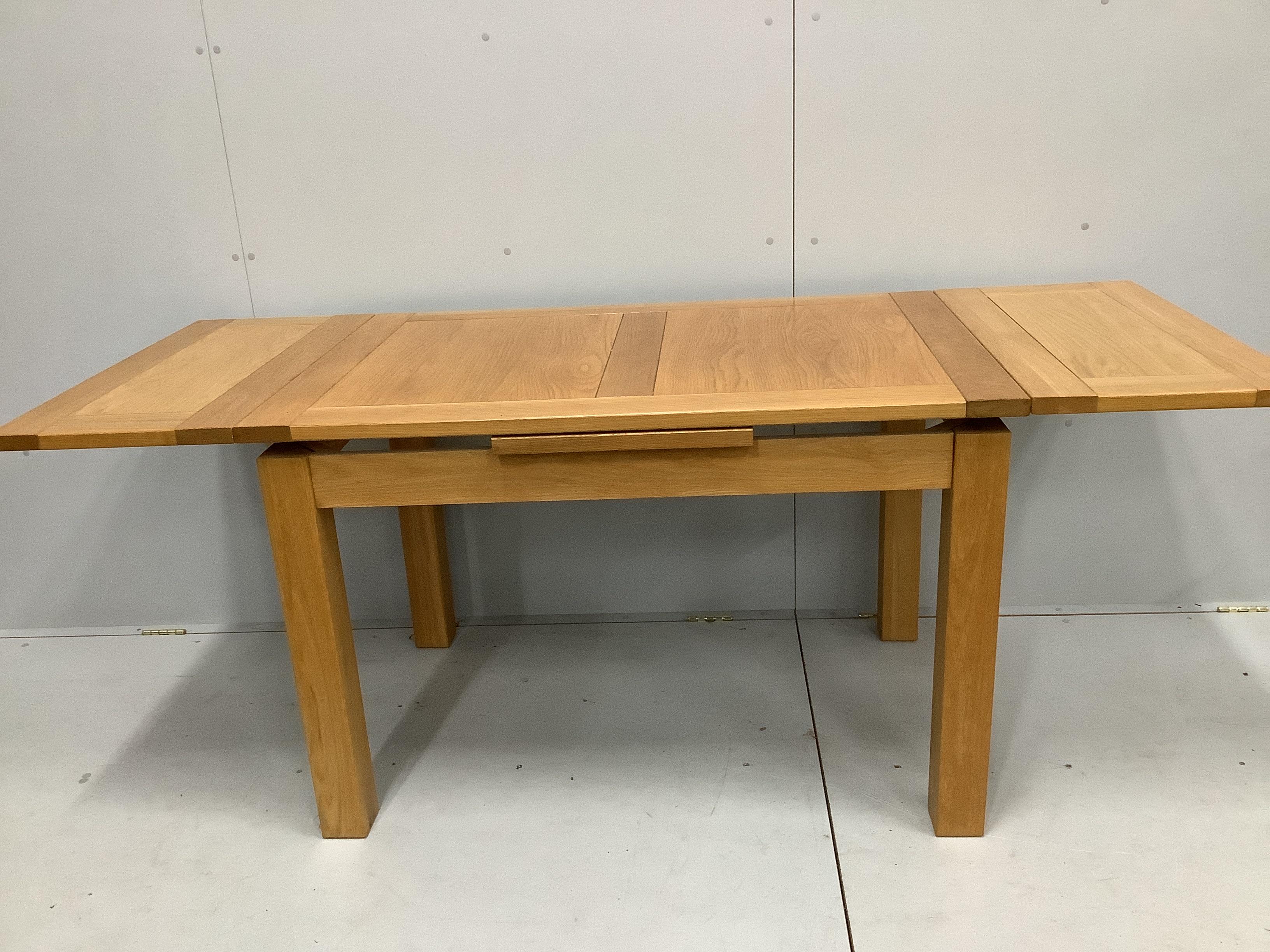 A contemporary oak draw leaf extending dining table, width 200cm extended, depth 80cm, height 78cm together with a set of four matching dining chairs